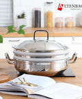 Stainless steel pot with lid on a kitchen counter next to an open cookbook, featuring the Altenbach brand.
