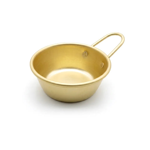 Gold-colored bowl with handle on a white background
