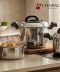 Stainless steel cookware set on a kitchen counter with Altenbach branding.