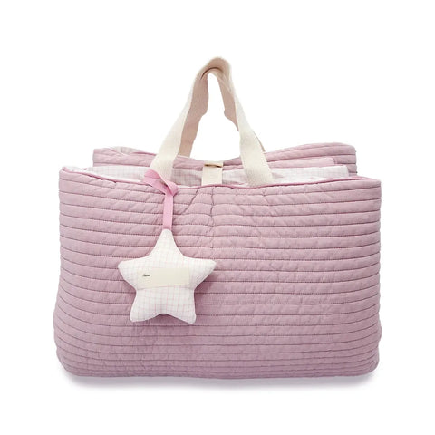 Pink quilted bag with a star-shaped toy on a white background
