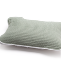 Green quilted pillow on a white background