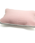 Pink quilted pillow on a white background