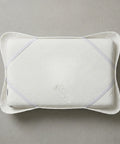 White quilted pillow cover with a quilt on a gray background