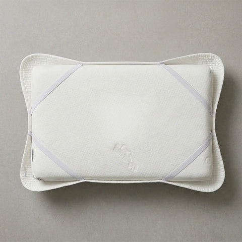 White quilted pillow cover with a quilt on a gray background