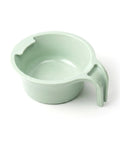 Light green plastic spoon holder cup with a handle on a white background