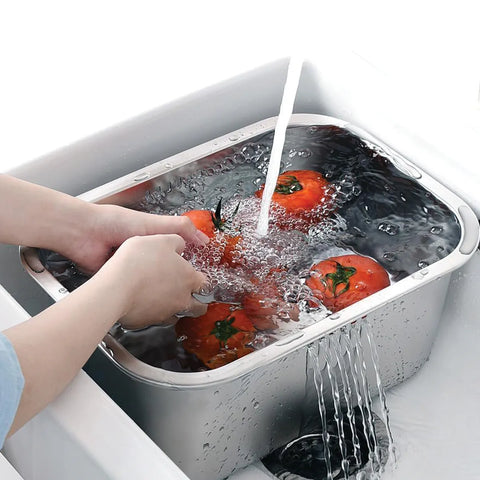 Tomatoes being washed in a small dish tub with running water