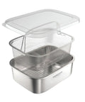 A stainless steel double-boiler steaming basket set with a clear plastic lid, shown on a clean white background.