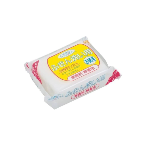 A packaged white bar of soap with a yellow and red label, photographed on a plain white background.