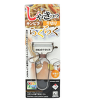 Japanese packaging for a stainless steel julienne peeler, featuring a clear plastic window showing the beige-and-black handled tool inside a printed card with product imagery and text.
