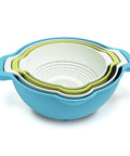 Set of three nesting colanders in blue, green, and white on a white background