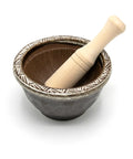 Ceramic mortar with a wooden pestle on a white background