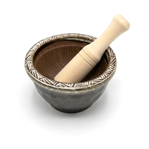Ceramic mortar with a wooden pestle on a white background