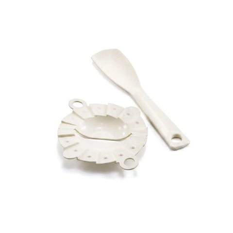 An off-white silicone mold and spatula set on a clean white background.