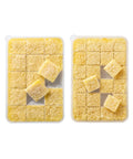 Two containers of minced garlic cubes in a food storage container on a white background