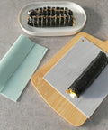 Sushi rolls on a textured white mat and wooden cutting board with a gray background