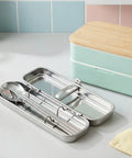 Stainless steel lunch box with cutlery on a kitchen counter