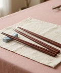 Wooden chopsticks on a beige cloth with a pink surface