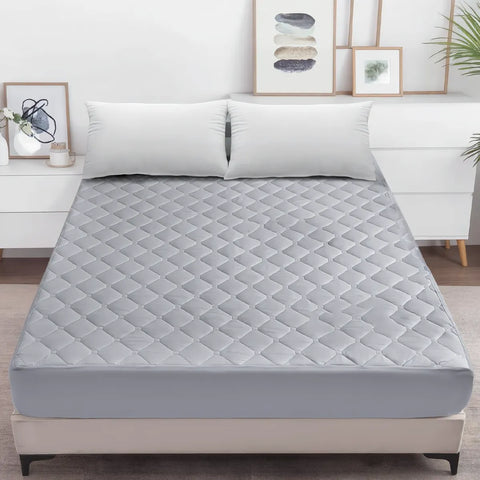 Gray mattress cover on a bed in a bedroom setting with decor elements.