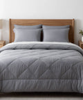 Gray quilted comforter on a bed with wooden headboard and nightstands in a bedroom setting.