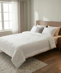 Neatly made bed with white bedding in a bright bedroom