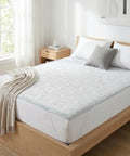 Bed with white bedding and a wooden headboard in a bright bedroom.