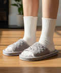 White socks with gray slippers on a wooden floor
