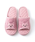 Pair of pink checkered slippers with cat faces on a white background
