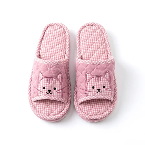 Pair of pink checkered slippers with cat faces on a white background
