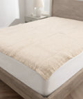 Beige mattress topper on a bed in a bedroom setting