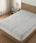 Bed with a gray mattress cover in a bedroom setting