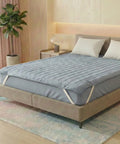 Bed with a blue mattress cover in a bedroom setting