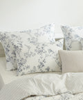 Floral patterned pillows on a bed with a neutral background