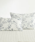 Floral patterned pillows on a bed with a white background