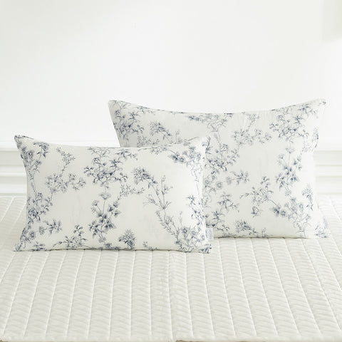 Floral patterned pillows on a bed with a white background