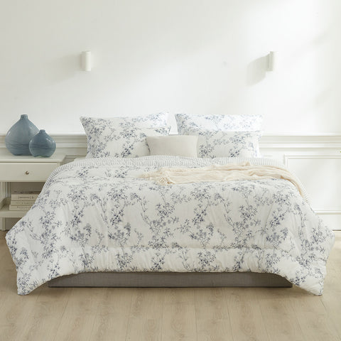 Floral patterned comforter set on a bed in a bedroom setting.