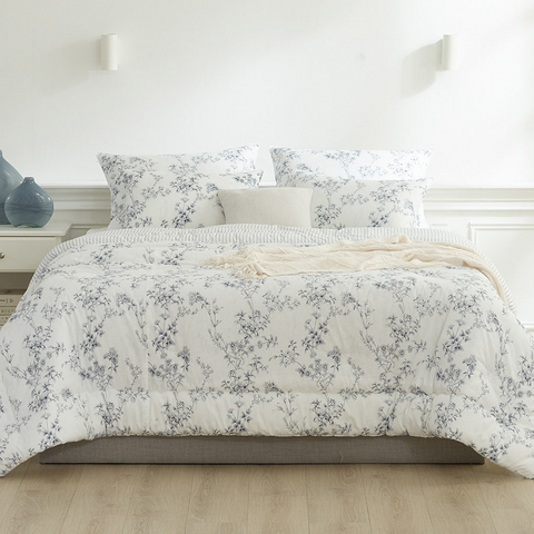 Floral patterned comforter on a bed in a bright bedroom