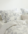 Floral patterned bedding set with pillows on a bed.