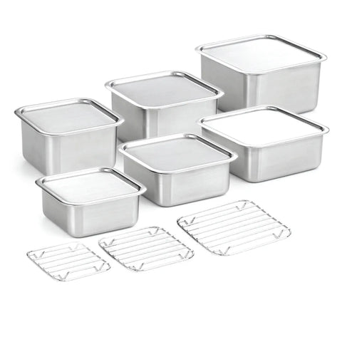 Set of stainless steel food container pans with wire racks on a white background