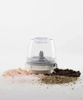 Clear pepper grinder with salt and pepper on a white background
