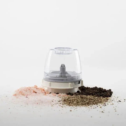 Clear pepper grinder with salt and pepper on a white background