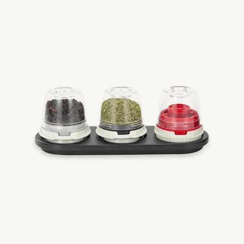 Set of three spice containers with lids on a white background