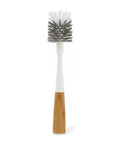 Bottle cleaning brush with wooden handle and white bristles on a white background