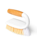 Cleaning brush with wooden handle and white bristles on a white background