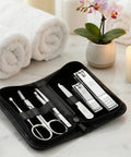 Manicure set in a black case on a marble surface with towels and a candle in the background.