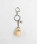 A novelty keychain featuring a miniature beige plastic bottle with black Korean text, a small South Korean flag charm, and a silver metal lobster clasp on a white background.