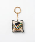 A square embroidered keychain charm featuring a depiction of kimbap, with a gold-tone split ring and chain, on a plain white background.