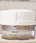 White kitchen appliance with a clear container on a light surface