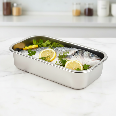 Stainless steel container with raw fish and lemon slices on a white surface