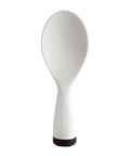 White rice paddle with textured surface on a white background