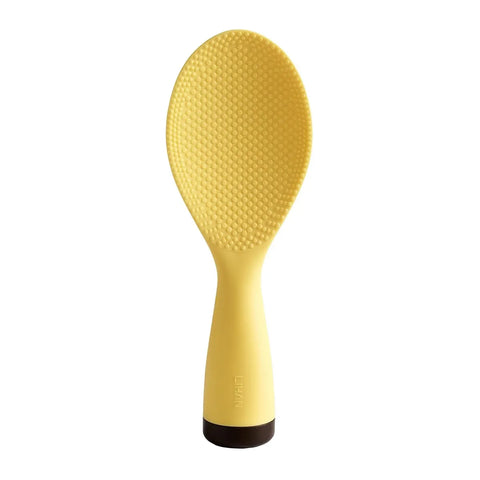Yellow rice paddle with textured surface on a white background